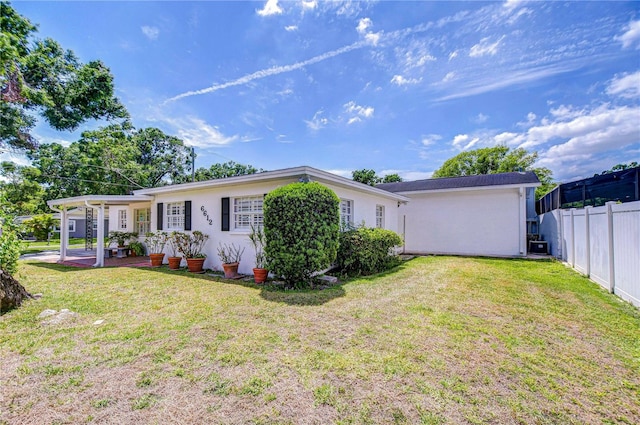 back of property featuring fence, a patio, a lawn, and stucco siding