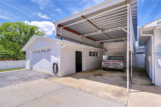 garage featuring a detached garage and fence