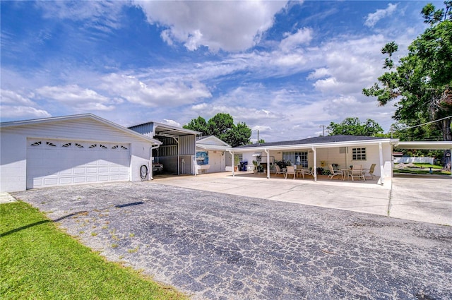 single story home featuring a carport and an outdoor structure