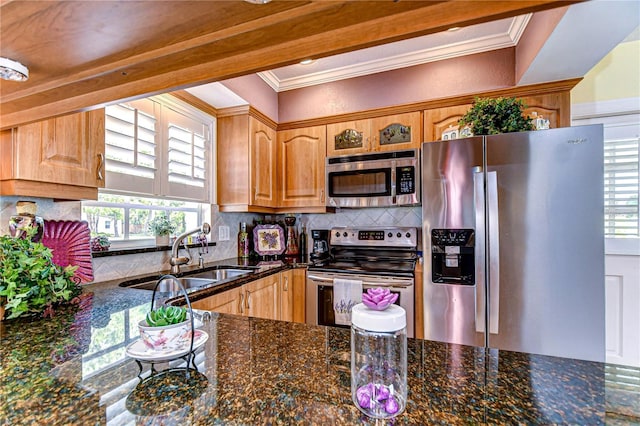 kitchen with dark stone countertops, tasteful backsplash, crown molding, a sink, and appliances with stainless steel finishes