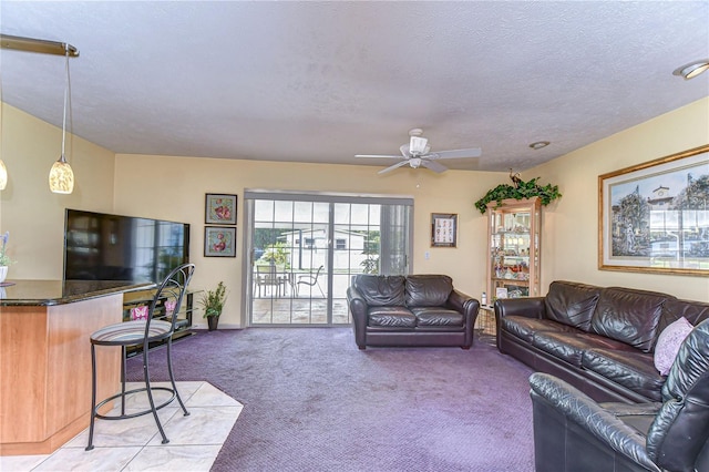 living room featuring a ceiling fan, light carpet, and a textured ceiling