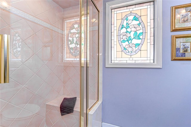bathroom with a stall shower and a healthy amount of sunlight