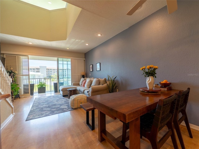 dining space featuring light wood finished floors, recessed lighting, a ceiling fan, and a textured wall