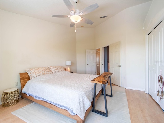 bedroom with light wood-style floors, a closet, a ceiling fan, visible vents, and vaulted ceiling