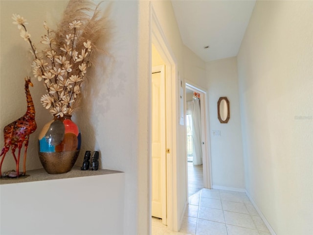hallway featuring baseboards and light tile patterned floors