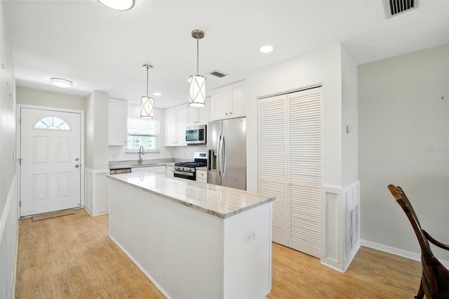 5925 Shore Blvd S Unit 611, Gulfport, FL 33707 - kitchen featuring stainless steel appliances, light wood-style flooring, white cabinetry, a center island, and recessed lighting
