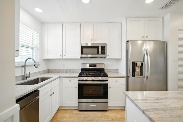 5925 Shore Blvd S Unit 611, Gulfport, FL 33707 - kitchen featuring appliances with stainless steel finishes, a sink, recessed lighting, white cabinetry, and light stone countertops