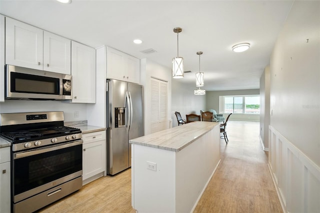 5925 Shore Blvd S Unit 611, Gulfport, FL 33707 - kitchen featuring appliances with stainless steel finishes, light wood finished floors, white cabinets, open floor plan, and recessed lighting
