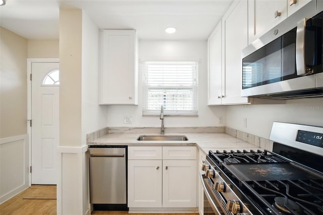 5925 Shore Blvd S Unit 611, Gulfport, FL 33707 - kitchen with stainless steel appliances, a sink, white cabinets, and recessed lighting