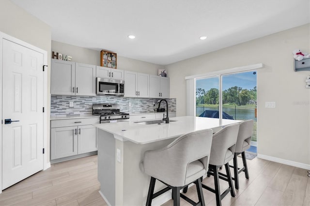 7721 Twin Leaf Ter, Parrish, FL 34219 - kitchen with decorative backsplash, a kitchen breakfast bar, light countertops, a sink, and stainless steel appliances