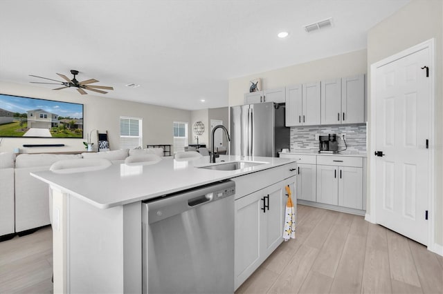 7721 Twin Leaf Ter, Parrish, FL 34219 - kitchen with visible vents, a sink, open floor plan, stainless steel appliances, and an island with sink