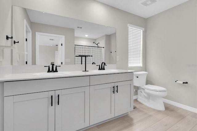 7721 Twin Leaf Ter, Parrish, FL 34219 - bathroom featuring wood finished floors, a sink, baseboards, toilet, and tiled shower
