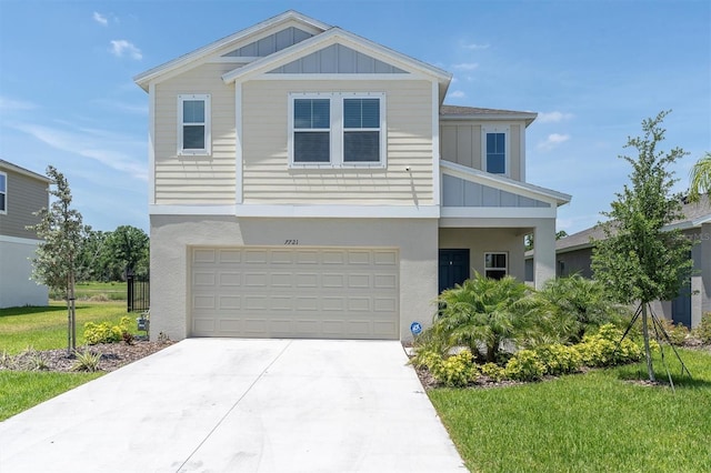 7721 Twin Leaf Ter, Parrish, FL 34219 - view of front of house with an attached garage, a front lawn, board and batten siding, stucco siding, and concrete driveway