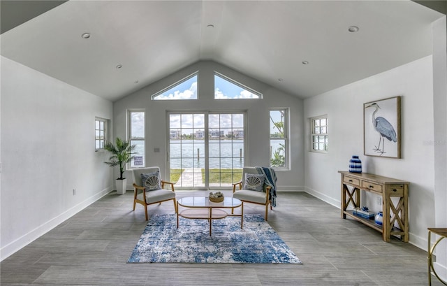 8635 Boca Ciega Dr, St Pete Beach, FL 33706 - living area with baseboards, a water view, wood finished floors, and vaulted ceiling