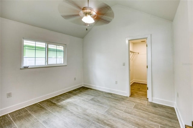8635 Boca Ciega Dr, St Pete Beach, FL 33706 - unfurnished bedroom with a closet, lofted ceiling, baseboards, a walk in closet, and a ceiling fan