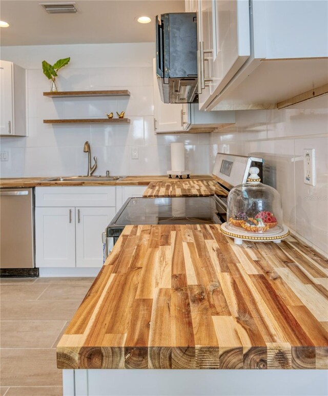 8635 Boca Ciega Dr, St Pete Beach, FL 33706 - kitchen featuring wooden counters, appliances with stainless steel finishes, open shelves, a sink, and white cabinets
