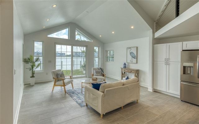 8635 Boca Ciega Dr, St Pete Beach, FL 33706 - living area with baseboards, light wood-type flooring, vaulted ceiling, and recessed lighting