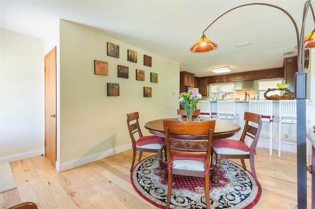 dining area featuring visible vents, baseboards, and light wood-type flooring