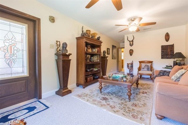 carpeted living room with visible vents, a ceiling fan, and baseboards