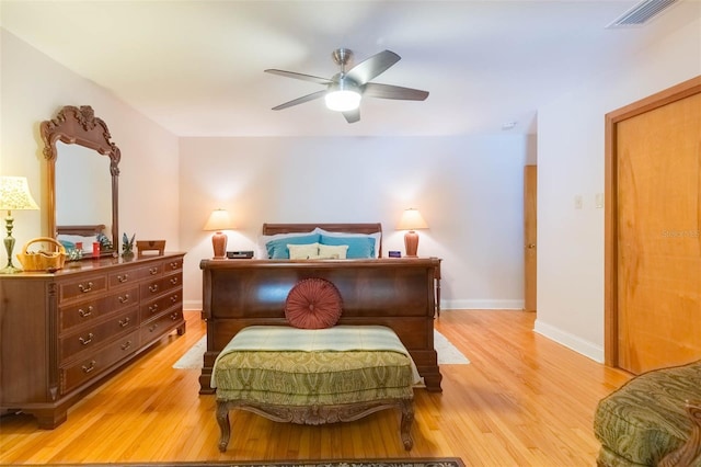 bedroom with light wood-style floors, a ceiling fan, baseboards, and visible vents
