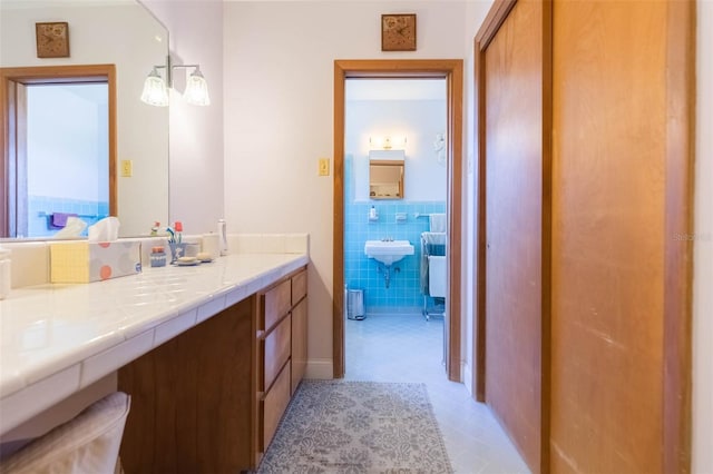 bathroom featuring tile walls, a wainscoted wall, and vanity