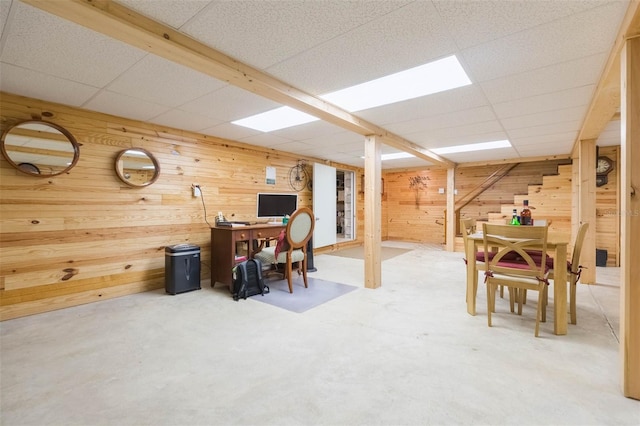 office featuring a paneled ceiling and wooden walls