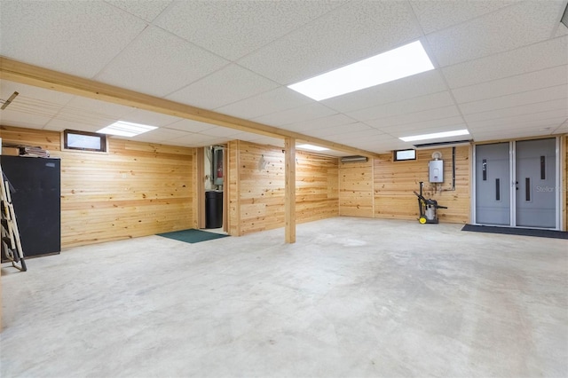 finished basement with wooden walls and a drop ceiling