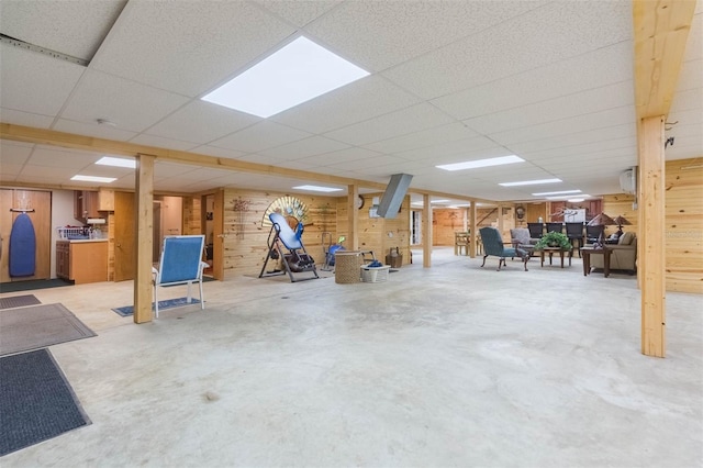 finished below grade area with a paneled ceiling and wooden walls