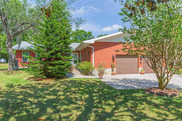 view of front of property with brick siding, a front lawn, an attached garage, and driveway