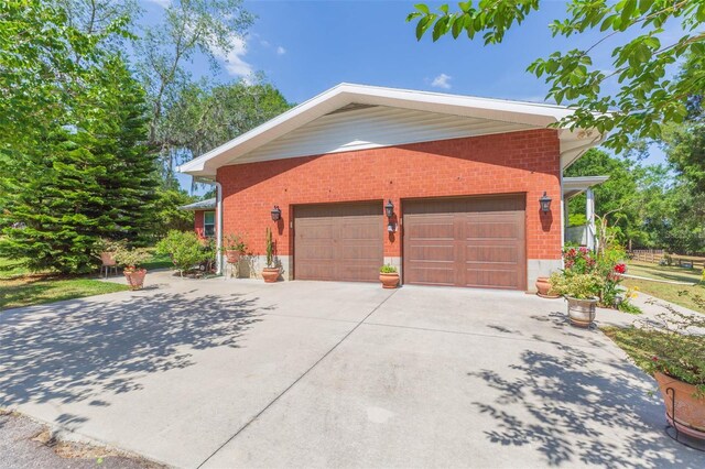 view of side of home featuring brick siding and concrete driveway