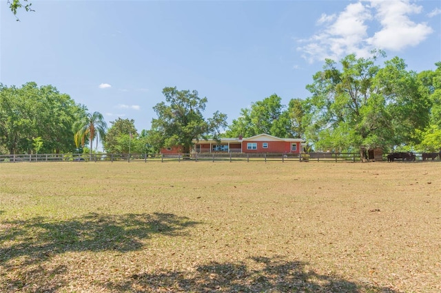 view of yard with a rural view and fence