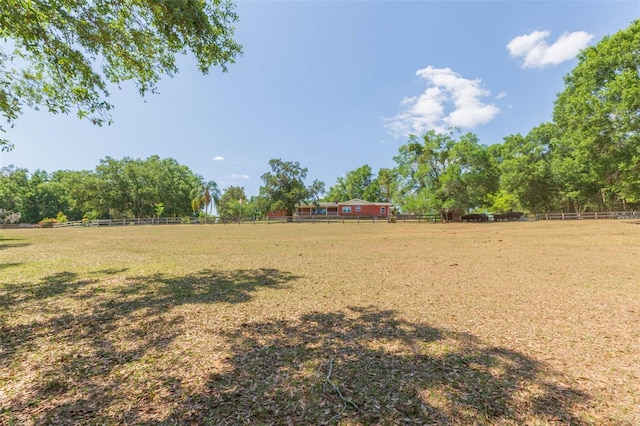 view of yard featuring a rural view and fence