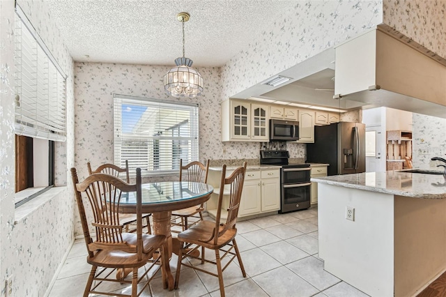 kitchen featuring appliances with stainless steel finishes, visible vents, glass insert cabinets, and wallpapered walls