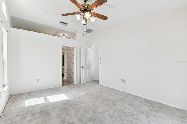 unfurnished bedroom with visible vents, vaulted ceiling, carpet floors, and baseboards