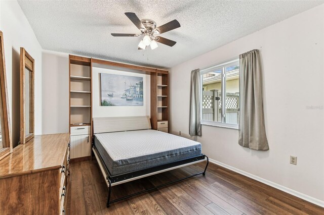 bedroom featuring baseboards, ceiling fan, a textured ceiling, and dark wood-style flooring