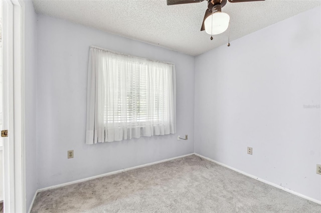 empty room featuring carpet, ceiling fan, baseboards, and a textured ceiling