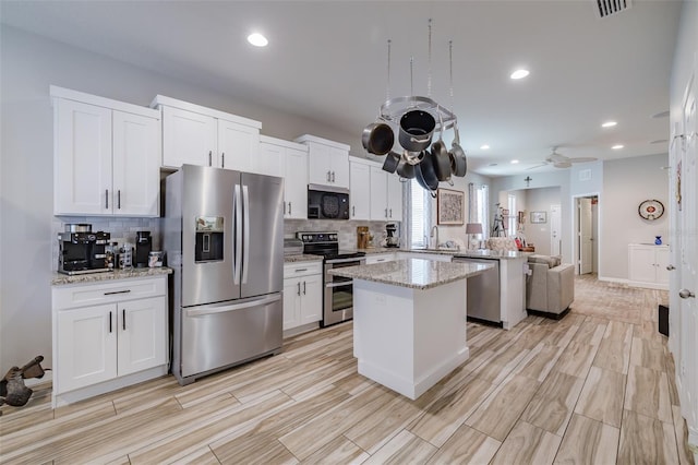 4516 Savannah Holly Pl, Riverview, FL 33578 - kitchen featuring a peninsula, a sink, visible vents, a kitchen island, and appliances with stainless steel finishes