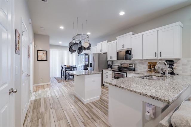 4516 Savannah Holly Pl, Riverview, FL 33578 - kitchen with stainless steel appliances, a sink, light stone countertops, a center island, and decorative backsplash