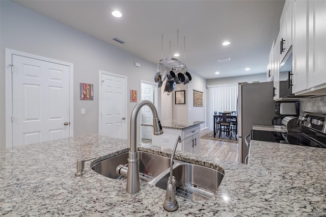 4516 Savannah Holly Pl, Riverview, FL 33578 - kitchen featuring white cabinets, light stone counters, a sink, and appliances with stainless steel finishes