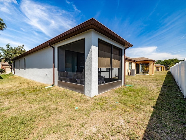 4516 Savannah Holly Pl, Riverview, FL 33578 - back of house featuring a sunroom, a lawn, stucco siding, and fence