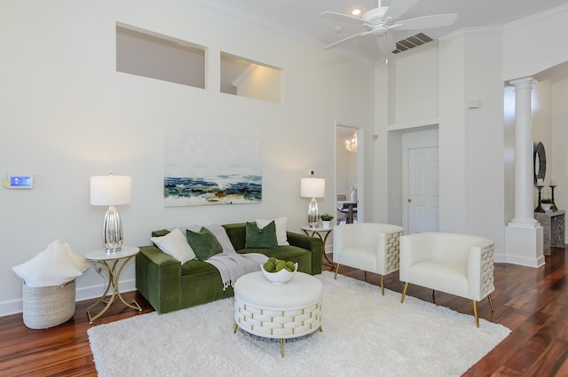 living room with visible vents, decorative columns, wood finished floors, and baseboards
