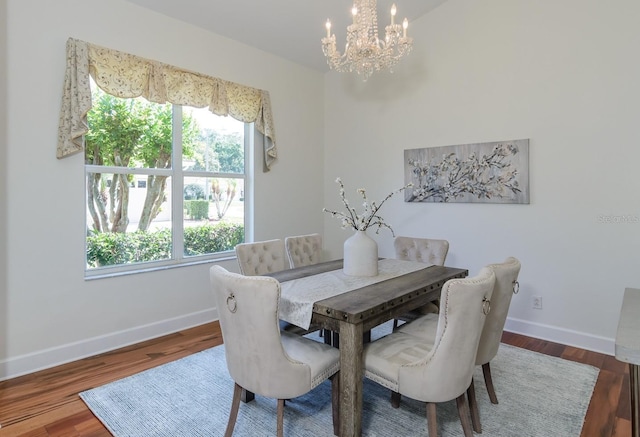 dining area featuring wood finished floors, a wealth of natural light, a chandelier, and baseboards