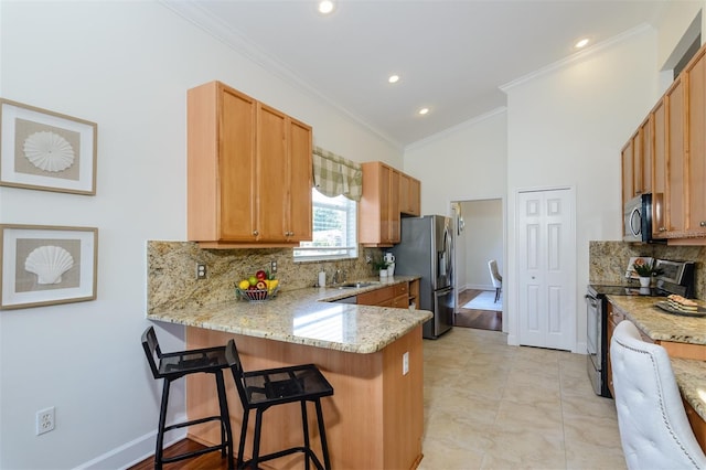 kitchen with stainless steel appliances, ornamental molding, backsplash, a peninsula, and a kitchen breakfast bar