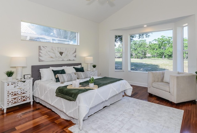 bedroom featuring baseboards, wood finished floors, multiple windows, and lofted ceiling