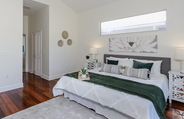 bedroom with visible vents, wood finished floors, and baseboards