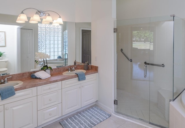 full bath with tile patterned flooring, a bath, and a sink