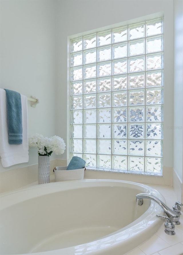 bathroom featuring a healthy amount of sunlight and a bath