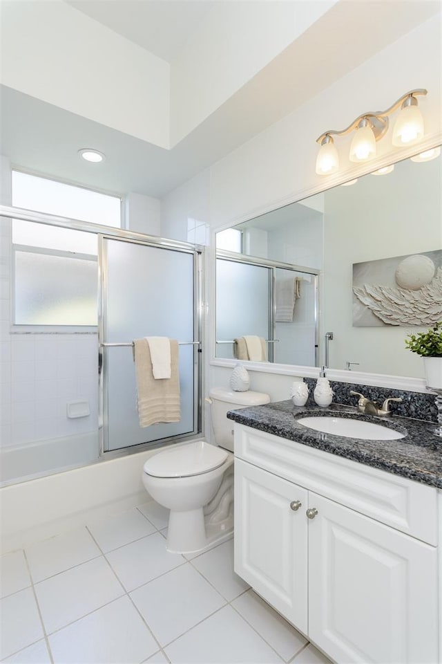 full bath with tile patterned floors, shower / bath combination with glass door, toilet, and vanity