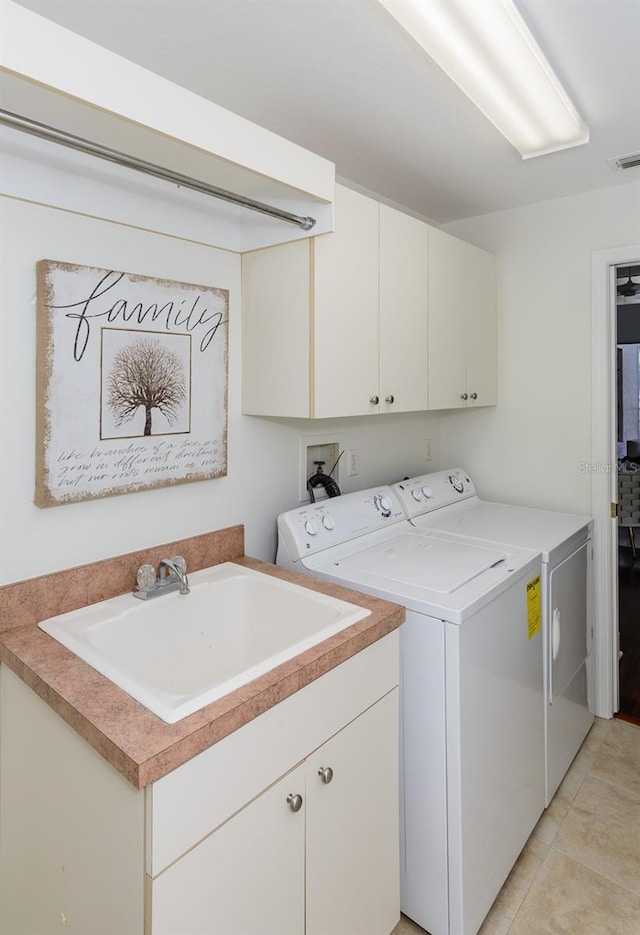 laundry area with light tile patterned floors, a sink, visible vents, washer and dryer, and cabinet space