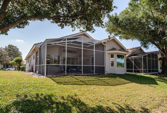 back of house with stucco siding, a yard, and glass enclosure